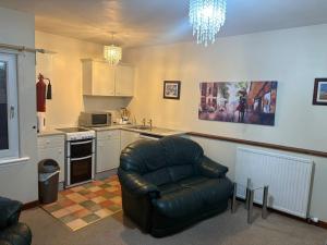 a living room with a leather chair in a kitchen at Queens Hotel Stonehaven in Stonehaven