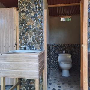 bagno con servizi igienici e parete in pietra di Camping Zona A dentro del PNN Tayrona a Santa Marta