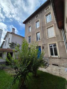 a building with a tree in front of it at Appartement à thermal in Nancy