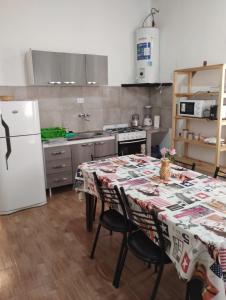 a kitchen with a table and a white refrigerator at Cabaña La Angostura in Fiambalá
