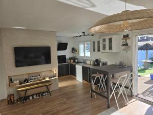 Maison au calme avec piscine في سان ميدارد-أون-جال: مطبخ مع بار وتلفزيون على الحائط