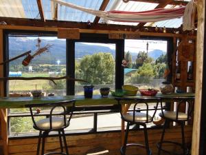 Una mesa y sillas en una habitación con una ventana grande. en Habitación en Casa Quilanto, en Coyhaique
