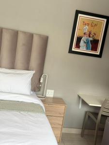 a bedroom with a bed and a desk and a picture at 12 At Jasmyn in Kriel