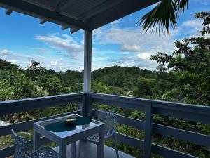 a balcony with a table and chairs and a view at L'O - Au cœur de la Grande Terre - T1 in Morne-à-lʼEau
