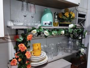 estante de cocina con platos, vasos y flores en Casa de praia VIP madre de Deus espaço inteiro térreo, en Madre de Deus