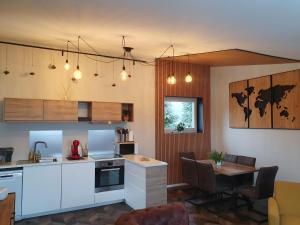 a kitchen with white cabinets and a table with chairs at Gite Le Gouttis in Tellancourt