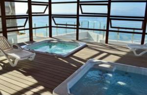 a jacuzzi tub on a deck with a chair at Jardin del Mar, Enjoy La Serena in Coquimbo