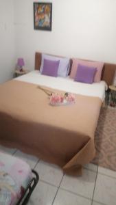 a large bed in a room with purple pillows at Vista de La Luna 4 rooms in Skála Foúrkas