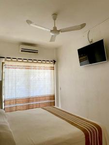una camera con letto e finestra con ventilatore a soffitto di Hotel Posada Casa del Abuelo a Santa Cruz Huatulco