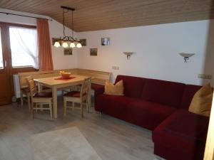 a living room with a red couch and a table at Haus im Kurpark in Reit im Winkl