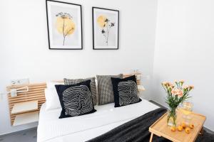 a bedroom with a white bed with black and white pillows at Casa Z Conil De La Frontera in Conil de la Frontera