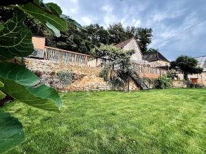 a stone wall in the yard of a house at La Grange aux Souvenirs - Piscine chauffée ,Jacuzzi et Terrain de pétanque in Grèzes