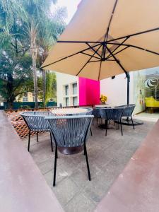 a group of chairs and tables with an umbrella at Hotel Consulado in Guadalajara
