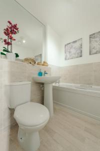 a bathroom with a toilet and a sink and a tub at RelaxingSleep Apartments in Glasgow