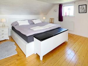 a large white bed in a bedroom with a window at 4 star holiday home in FäRJESTADEN in Färjestaden