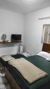 a bedroom with a bed and a tv on the wall at Excelente Casa de campo perto de BH in Capim Branco