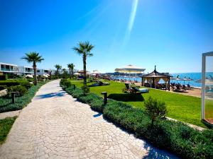 a brick path next to a beach with palm trees at 4Seasons Ciprus 1+1 in Boğaz