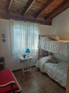 Un dormitorio con dos literas y una mesa. en Nuestro Lugar, en Villa Gesell