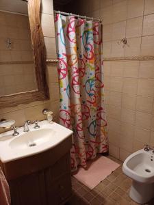 a bathroom with a sink and a shower curtain at Nuestro Lugar in Villa Gesell +51 photos