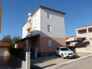 Un coche blanco aparcado delante de un edificio en Burle Apartment with FREE private parking, en Medulin