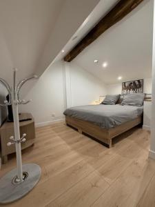 een slaapkamer met een bed en een houten vloer bij La Demeure du Chevalier in Saint-Cyr-lʼÉcole