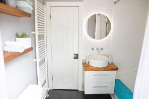 een badkamer met een wastafel en een spiegel bij KingstonStays Spacious Historic Downtown Stableman's House Loft in Kingston +28 foto's