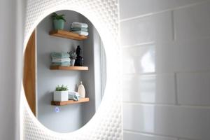 a bathroom with a round mirror and towels at KingstonStays Spacious Historic Downtown Stableman's House Loft in Kingston