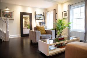 een woonkamer met een fauteuil en een tafel bij KingstonStays Spacious Historic Downtown Stableman's House Loft in Kingston