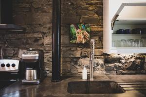 a kitchen sink with a picture of a chicken on the wall at KingstonStays Spacious Historic Downtown Stableman's House Loft in Kingston +24 photos