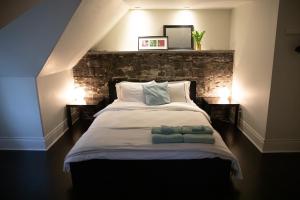 a bedroom with a large bed with two towels on it at KingstonStays Spacious Historic Downtown Stableman's House Loft in Kingston
