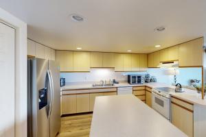 a kitchen with wooden cabinets and stainless steel appliances at Whaler's Getaway in Depoe Bay +18 photos