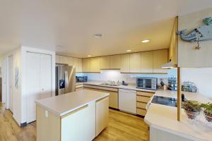 a kitchen with white cabinets and a counter top at Whaler's Getaway in Depoe Bay