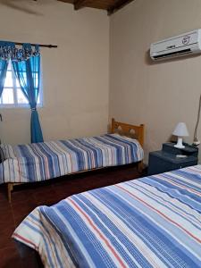 ein Schlafzimmer mit zwei Betten und einem Fenster in der Unterkunft Chacra el Cacique in Curuzú Cuatiá