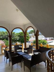 balcone con tavoli, sedie e finestre di Hotel Posada Casa del Abuelo a Santa Cruz Huatulco