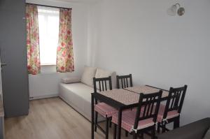 ein Wohnzimmer mit einem Tisch, Stühlen und einem Sofa in der Unterkunft Biały Dom in Ustka