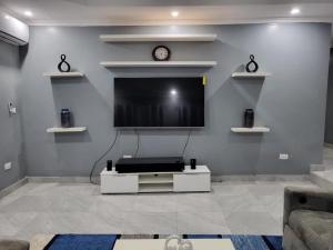a living room with a flat screen tv on a wall at Dream Stay in Brusubi