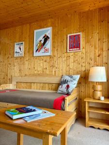 a bedroom with a bed and a wooden wall at Appartement 4 personnes - Magnifique vue montagne in Méribel +24 photos