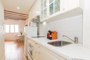 シッチェスにあるApartamentos Mayor by Habama Groupの白いキャビネットとシンクのあるキッチン