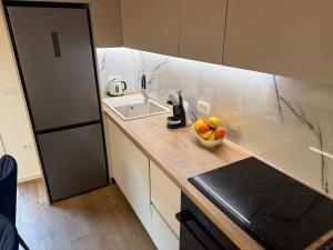 a kitchen with a sink and a bowl of fruit on a counter at Luxury apartment Gabi 1 in Slavonski Brod +18 photos
