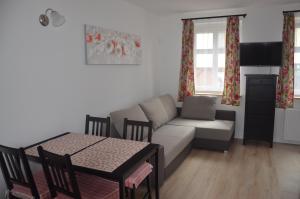 ein Wohnzimmer mit einem Sofa und einem Tisch in der Unterkunft Biały Dom in Ustka