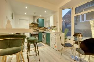 a kitchen with green cabinets and a glass table at Holiday Home in Central Southsea in Portsmouth