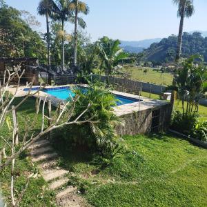 a swimming pool in a yard with palm trees at Casa Suíça família-luxo nr4 Suite master 5-pessoas in Pomerode