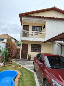 um carro vermelho estacionado em frente a uma casa em Acaiaca em Piúma