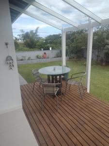 a patio with a table and chairs on a deck at Casa de praia na Gamboa - Garopaba SC in Garopaba