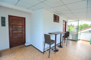 a room with a table and chairs and a door at Green Gate House Rooms in Kochchikade