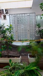 a bench in front of a window with plants at Apartamento em Cabo Frio - Praia do Forte in Cabo Frio