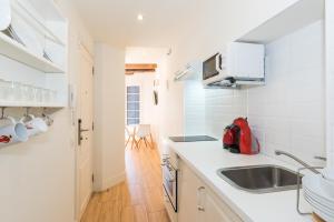 シッチェスにあるApartamentos Mayor by Habama Groupのシンクとカウンタートップのあるキッチン