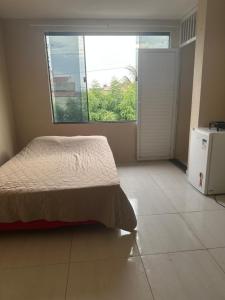 Un dormitorio con una cama y una ventana grande. en Ap martins, en Sobral