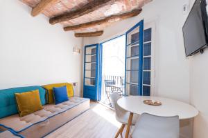 a living room with a couch and a table at Apartamentos Mayor by HABAMA in Sitges