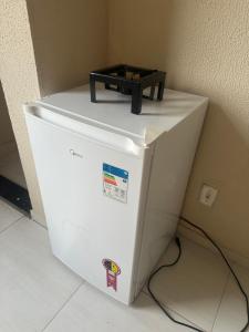 una nevera blanca con un estante encima en Ap martins, en Sobral